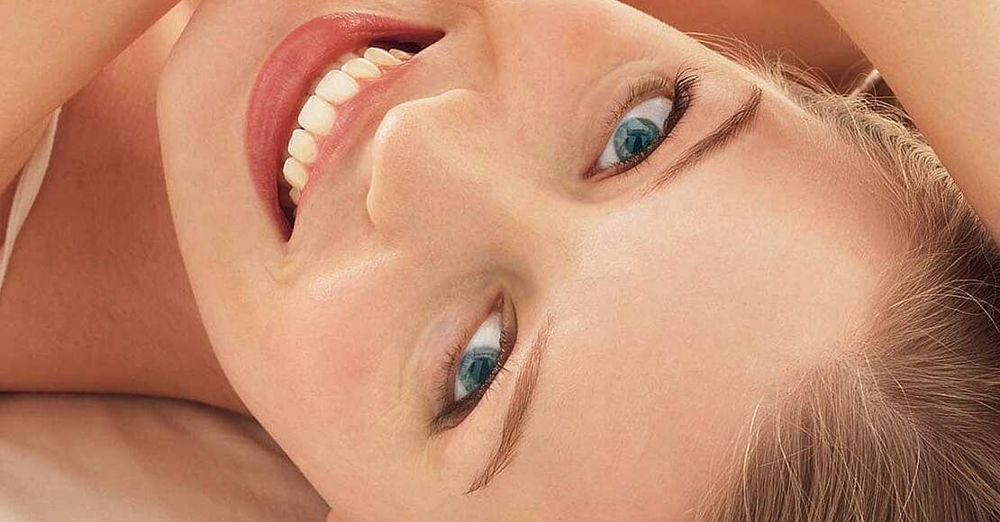 Titelbild Pressemitteilung Herbst-Blues adé: Wohlfühl-Tipps für Kontaktlinsenträger Glückliche Frau im Liegen, Wohlfühl-Tipps