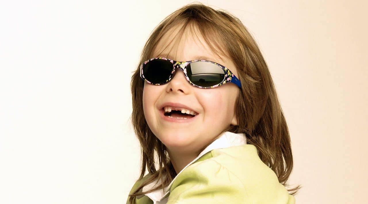 Titelbild Pressemitteilung Baby-Sonnenbrillen und Kinder-Sonnenbrillen – wie Kleinkinder richtig geschützt werden! Siebenjähriges Mädchen, lachend, mit einer Kinder-Sonnenbrille