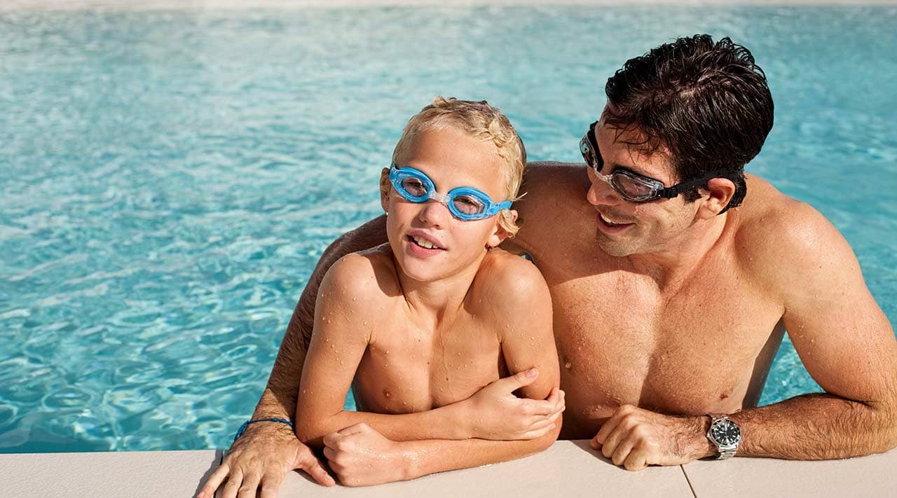 Titelbild Pressemitteilung Badeurlaub: Wer nicht gut sieht, schwimmt gefährlich Vater und Sohn mit Schwimmbrillen am Beckenrand